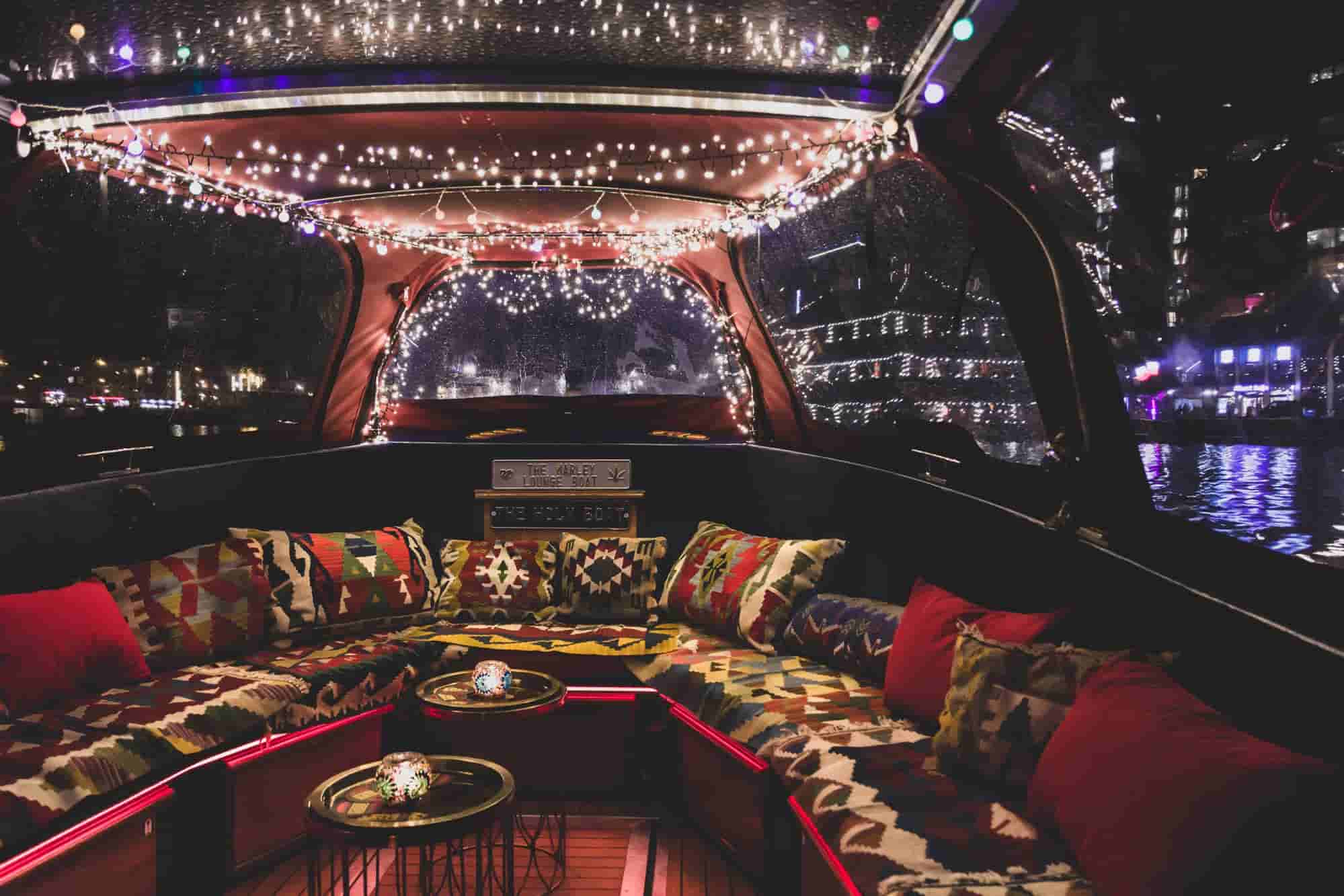 Interieur van Buddha Lounge Boot met rode kussens en sfeerverlichting